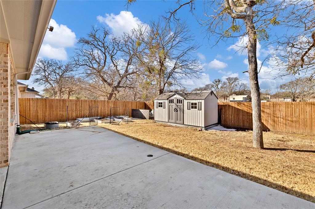 137 Gardenia Drive Azle, TX 76020 - Photo 30 of 38 Fenced backyard featuring a patio and a storage unit