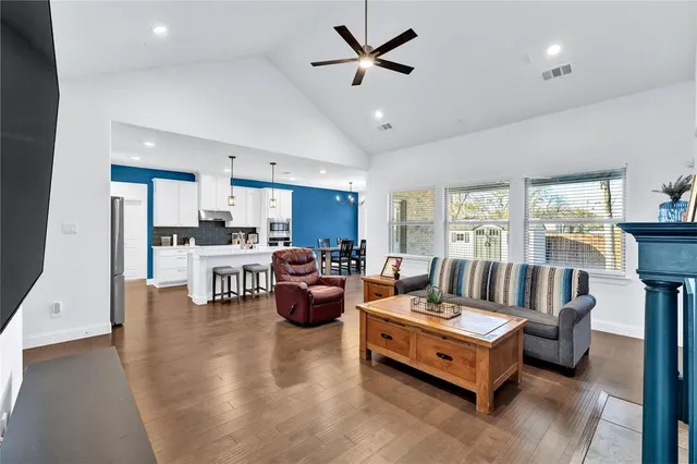 a living room with furniture kitchen view and a large window