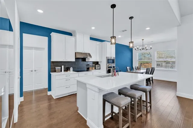a large white kitchen with kitchen island a table and chairs