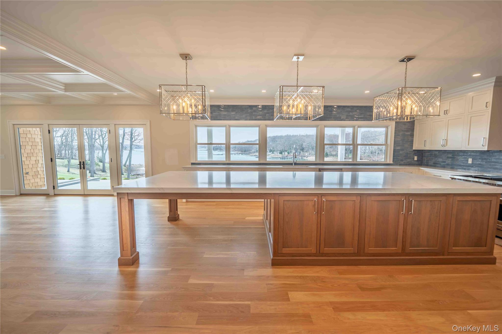 106 Cove Road Asharoken, NY 11768 - Photo 6 of 46 Kitchen with hanging lights, two tone cabinets, light wood-style flooring, a large island, and plenty of natural light