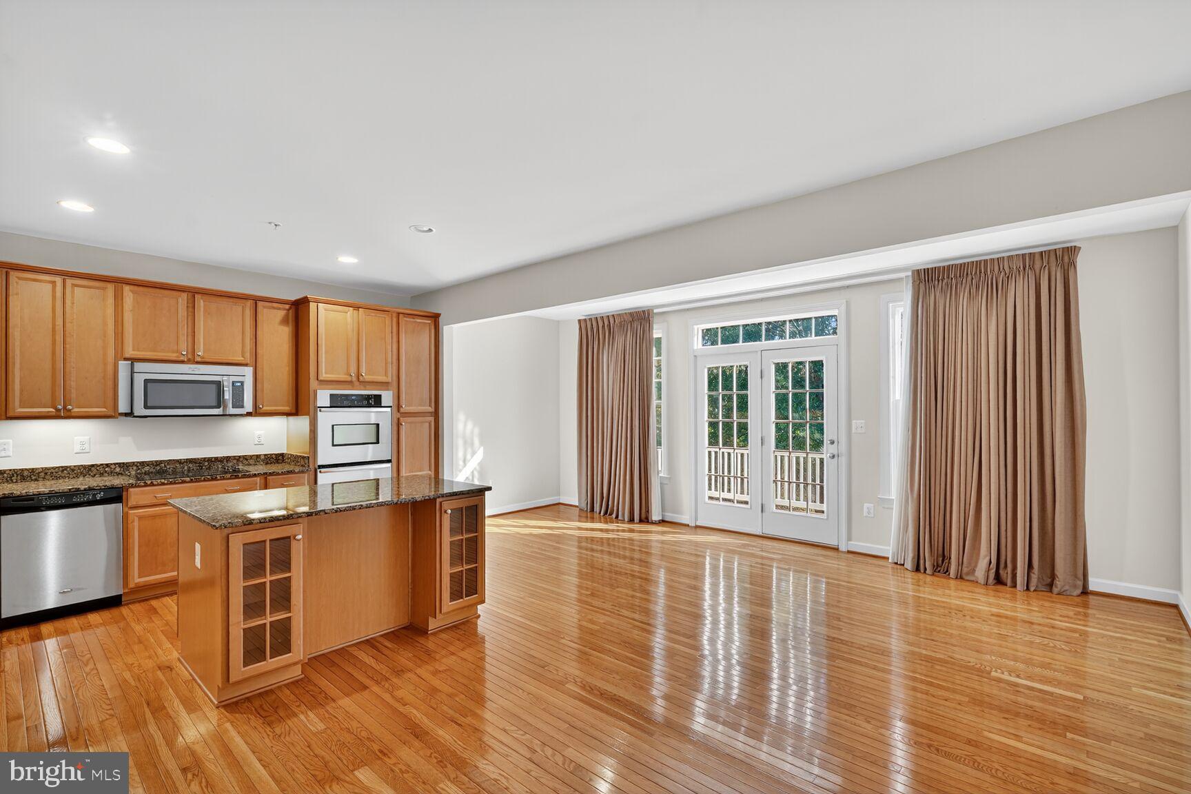 1755 Chiswick Court Silver Spring, MD 20904 - Photo 7 of 34 a open kitchen with stainless steel appliances granite countertop a stove top oven a sink dishwasher and a microwave oven with wooden floor