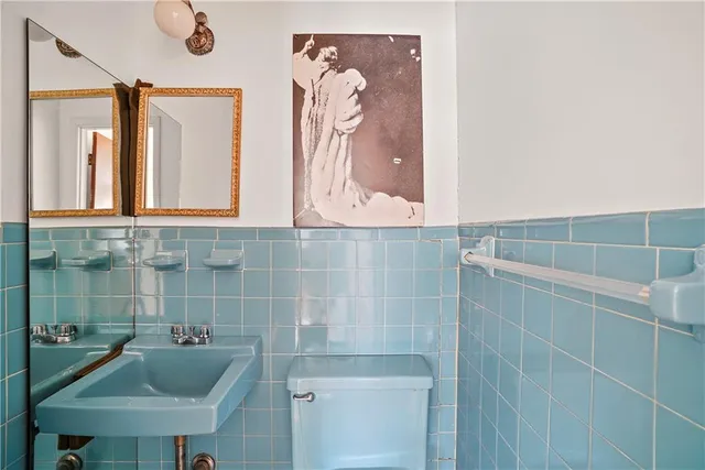 a bathroom with a sink a toilet and mirror