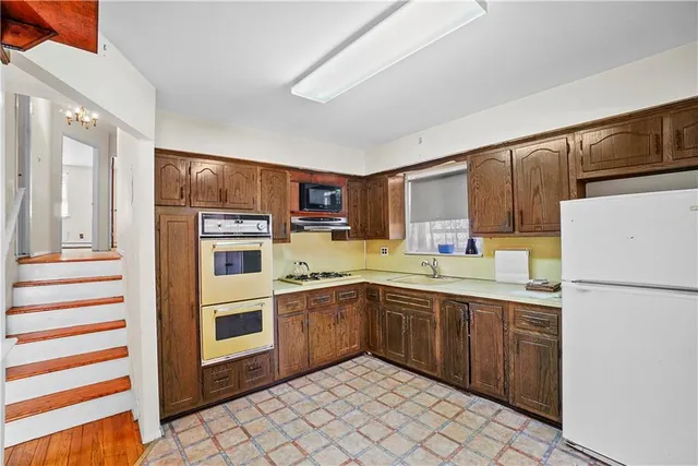a kitchen with white cabinets and white appliances
