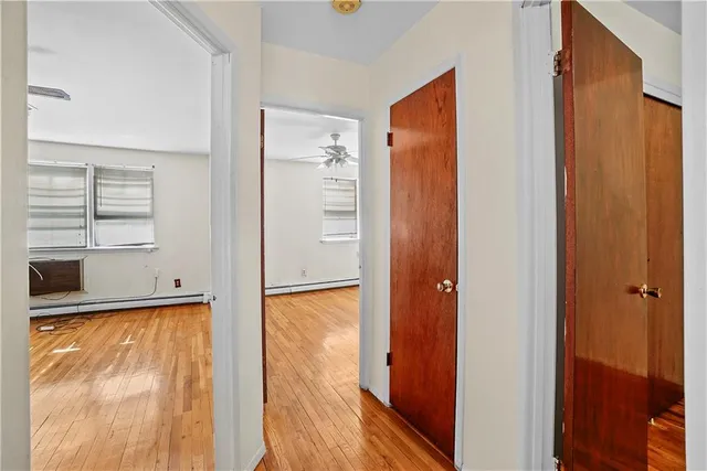 a view of a hallway with wooden floor and door