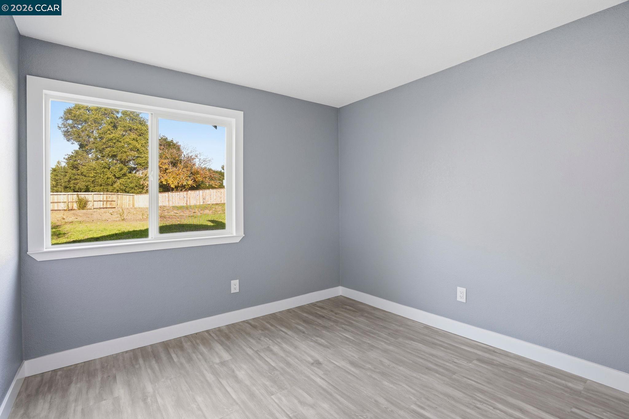 834 Coral Ridge Circle Rodeo, CA 94572 - Photo 16 of 32 a view of an empty room with wooden floor and a window