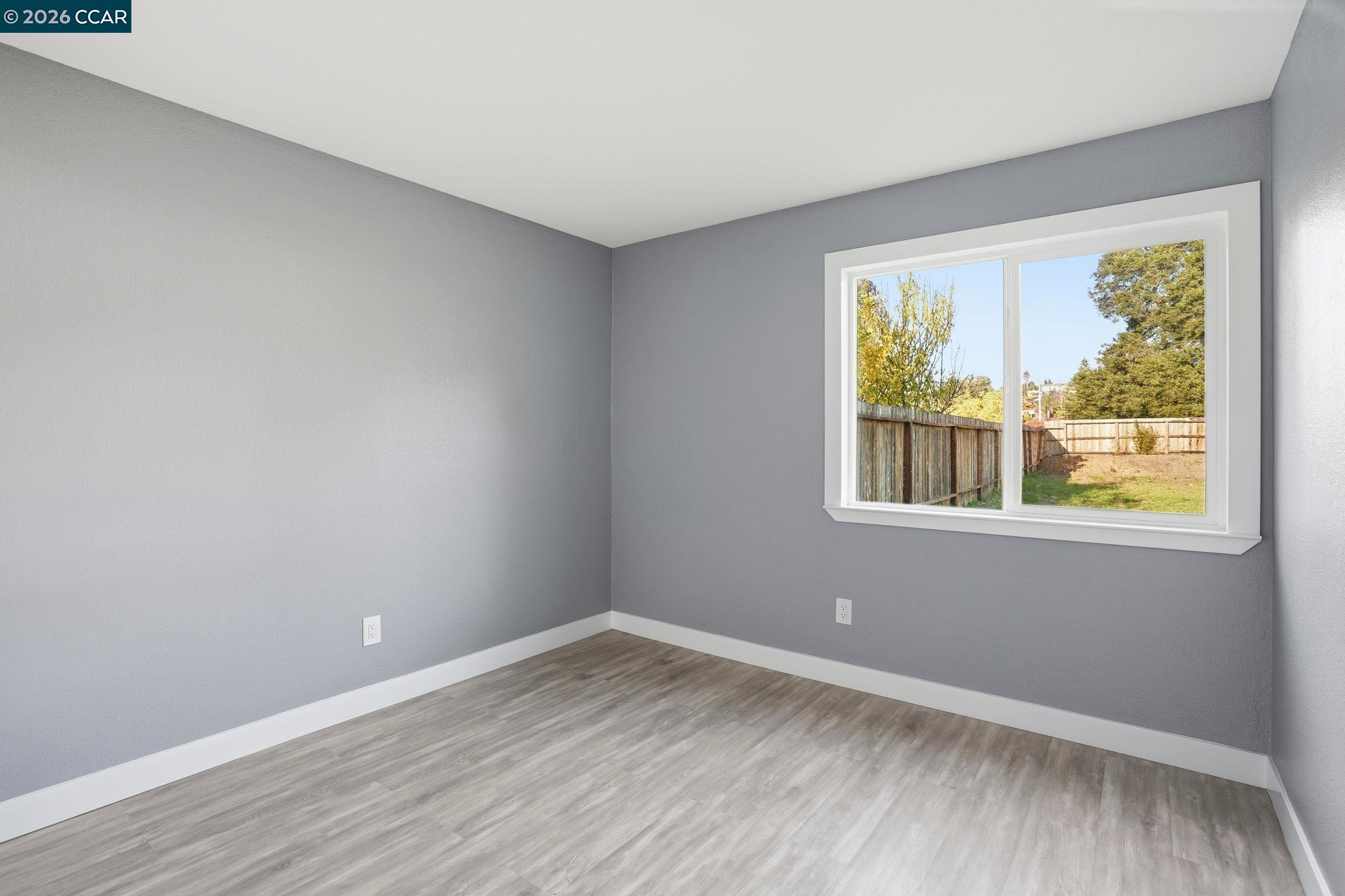 834 Coral Ridge Circle Rodeo, CA 94572 - Photo 18 of 32 a view of an empty room with wooden floor and a window