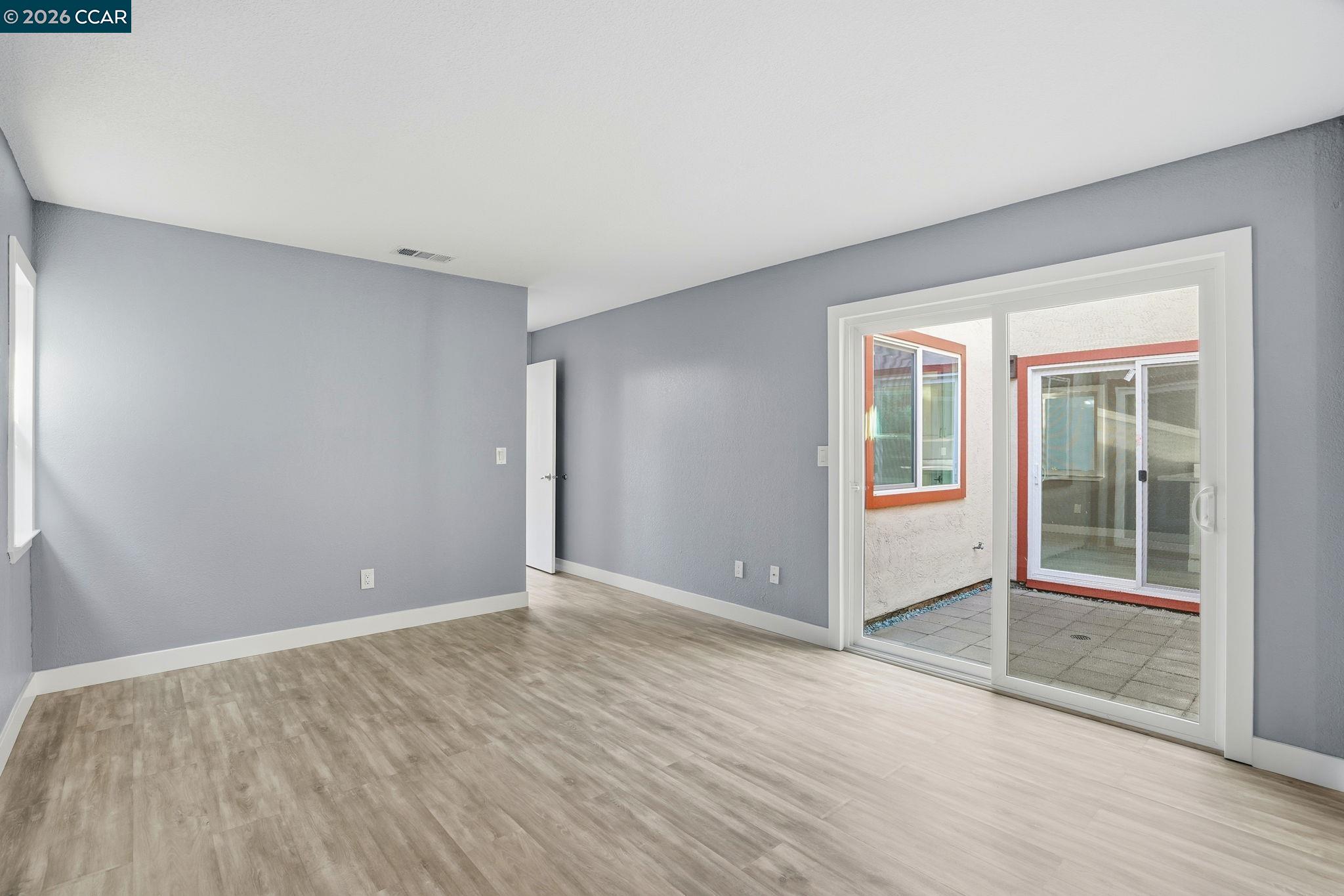 834 Coral Ridge Circle Rodeo, CA 94572 - Photo 23 of 32 a view of an empty room with wooden floor and a window