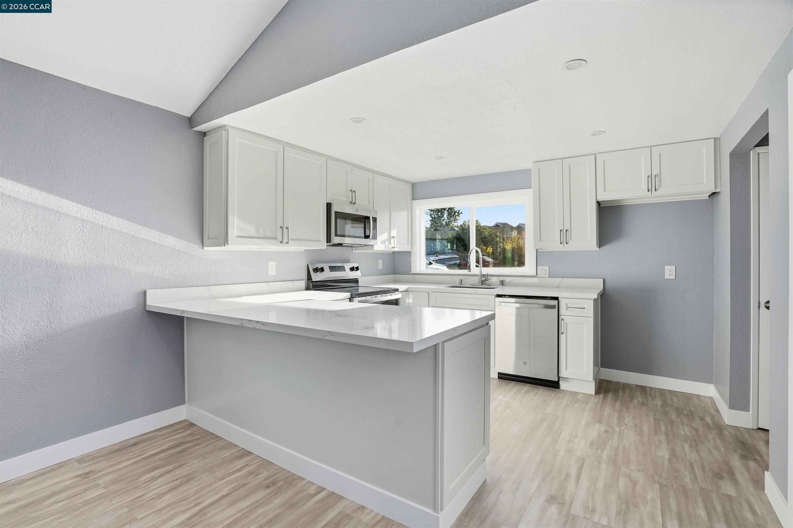 834 Coral Ridge Circle Rodeo, CA 94572 - Photo 7 of 32 a kitchen with a sink cabinets stainless steel appliances and wooden floor