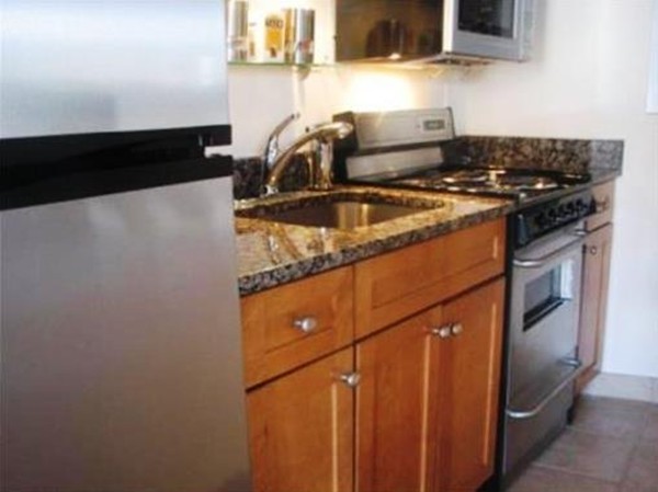 12 Stoneholm Street, Unit 520 Boston, MA 02115 - Photo 5 of 27 a kitchen with a stove and a refrigerator