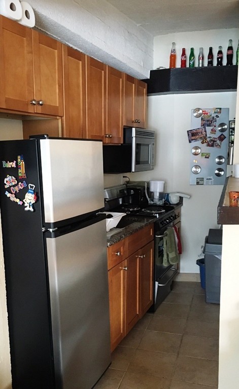 12 Stoneholm Street, Unit 520 Boston, MA 02115 - Photo 6 of 27 a white refrigerator freezer sitting inside of a kitchen
