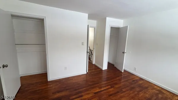 an empty room with wooden floor and entrance