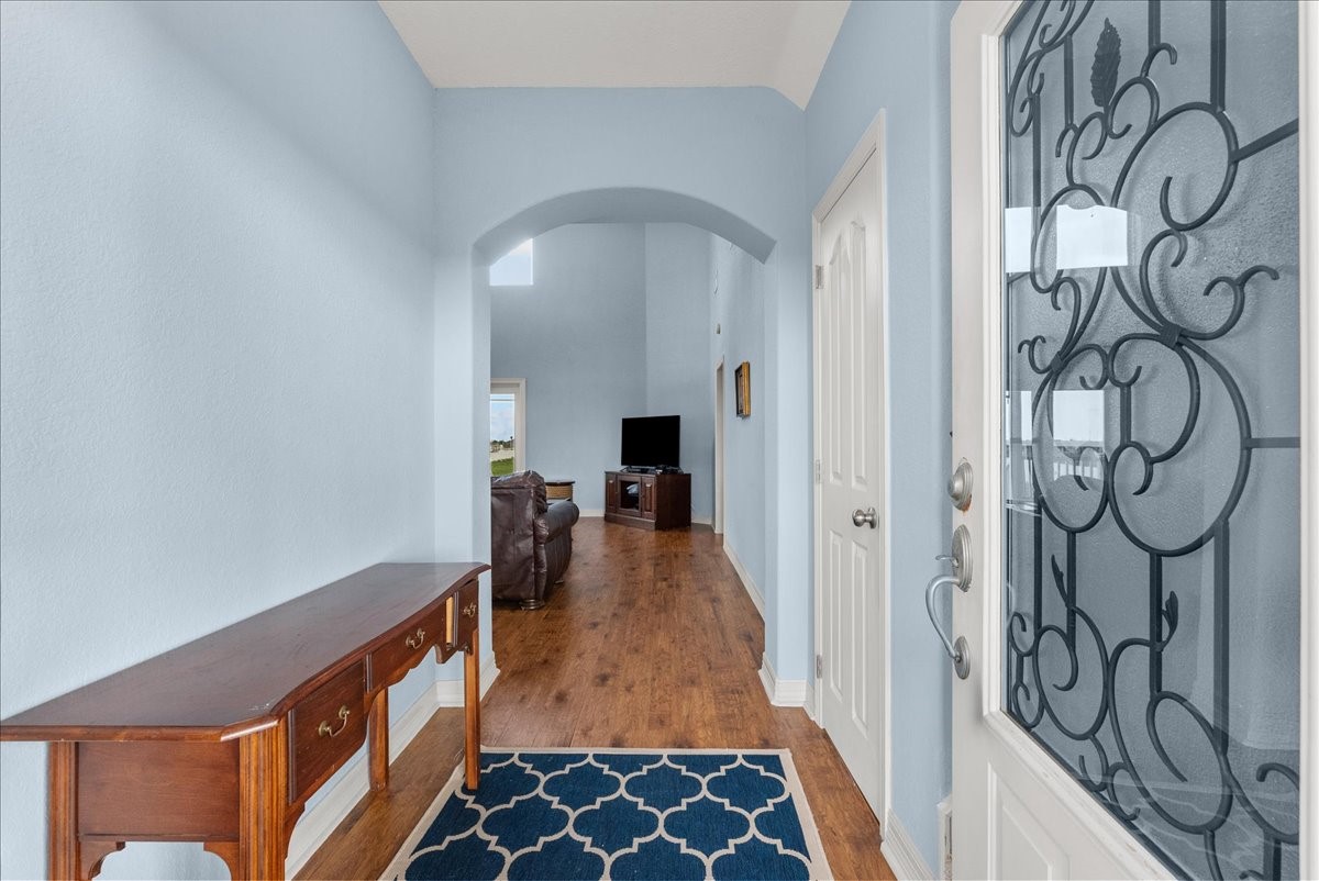 211 Tuna Run Freeport, TX 77541 - Photo 14 of 48 A welcoming entryway with wood flooring leads to a cozy living room.