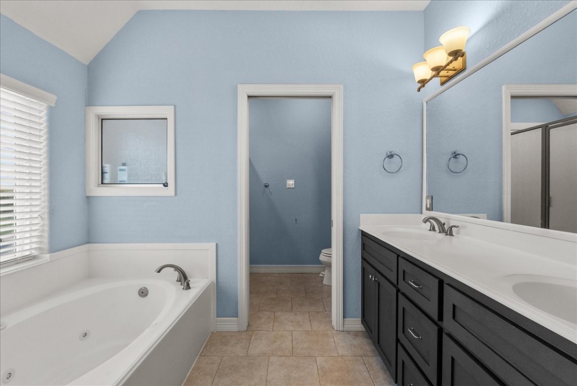 211 Tuna Run Freeport, TX 77541 - Photo 28 of 48 This bathroom features a large jetted tub and dual sinks. The water closet includes a separate shower.