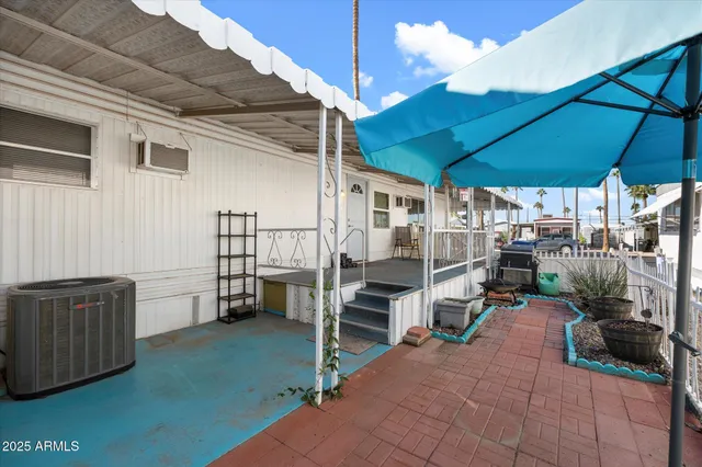a view of a patio with table and chairs under an umbrella