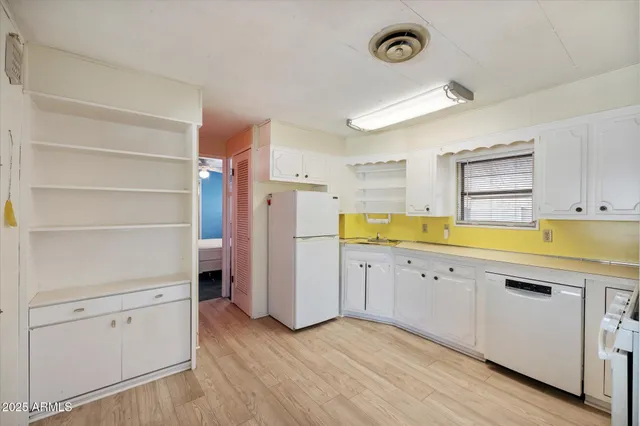 a view of a kitchen with cabinets and wooden floor