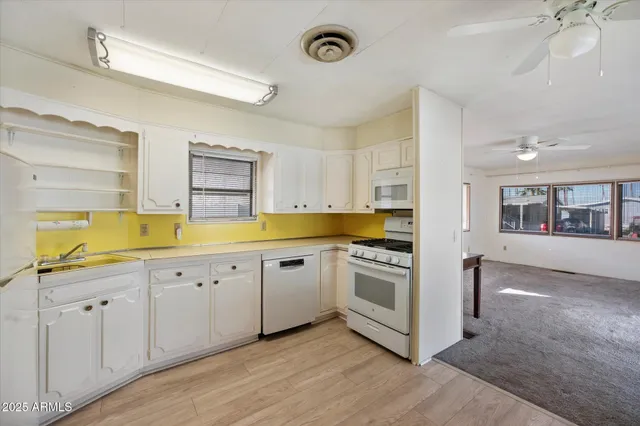 a kitchen with granite countertop a sink a stove and cabinets