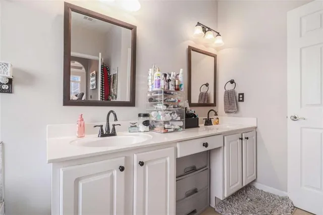 a bathroom with double vanity sinks and a mirror