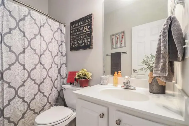 a bathroom with a sink a toilet and a shower curtain