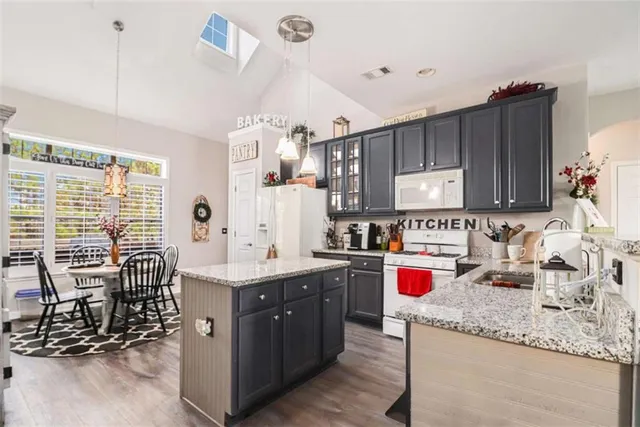a kitchen with a sink stove and chairs