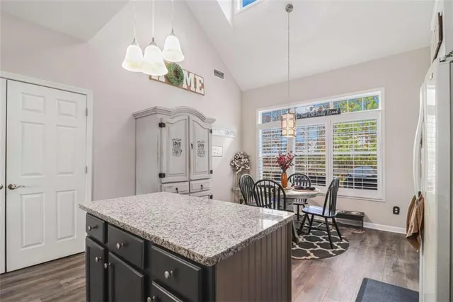 a kitchen with a table chairs and wooden floor
