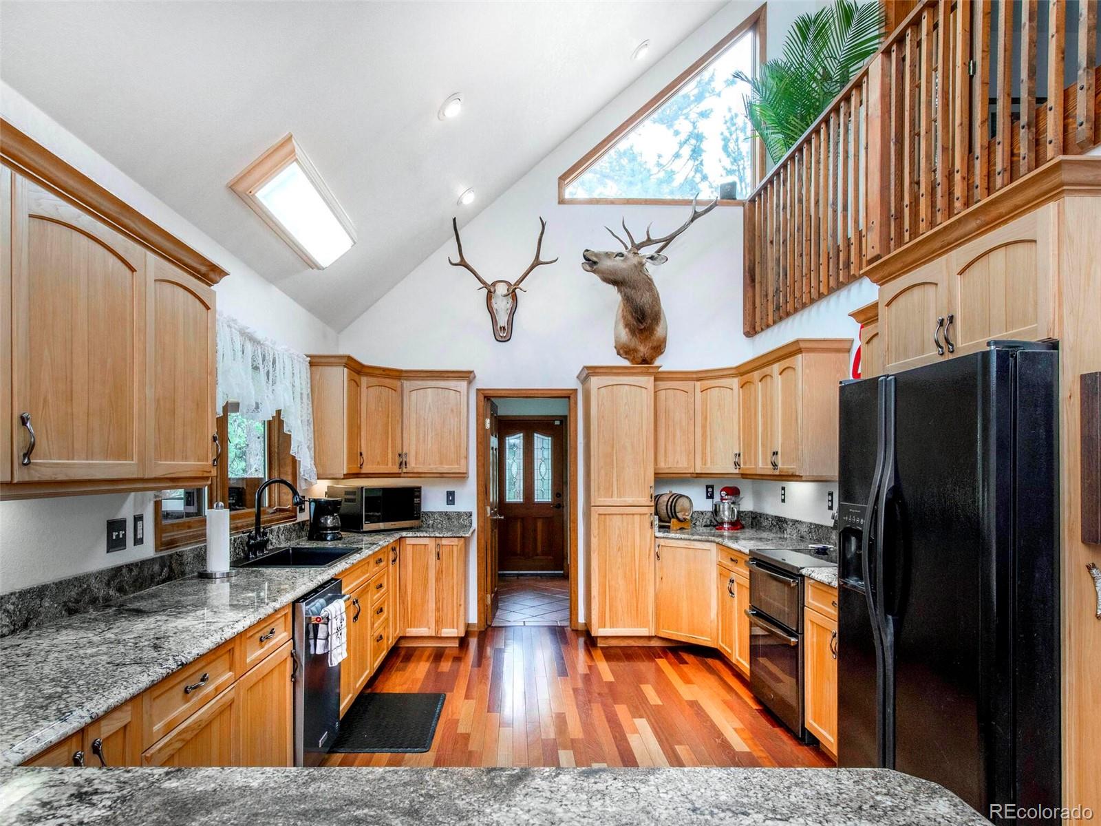 503 Conestoga Road Bailey, CO 80421 - Photo 12 of 40 a kitchen with stainless steel appliances granite countertop a refrigerator a stove top oven a sink and dishwasher