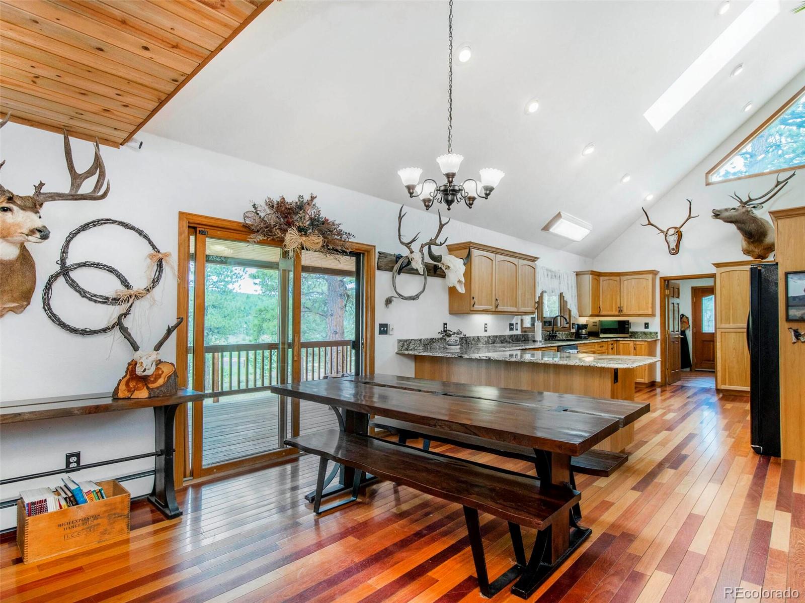 503 Conestoga Road Bailey, CO 80421 - Photo 16 of 40 a view of a dining room with furniture a chandelier and wooden floor