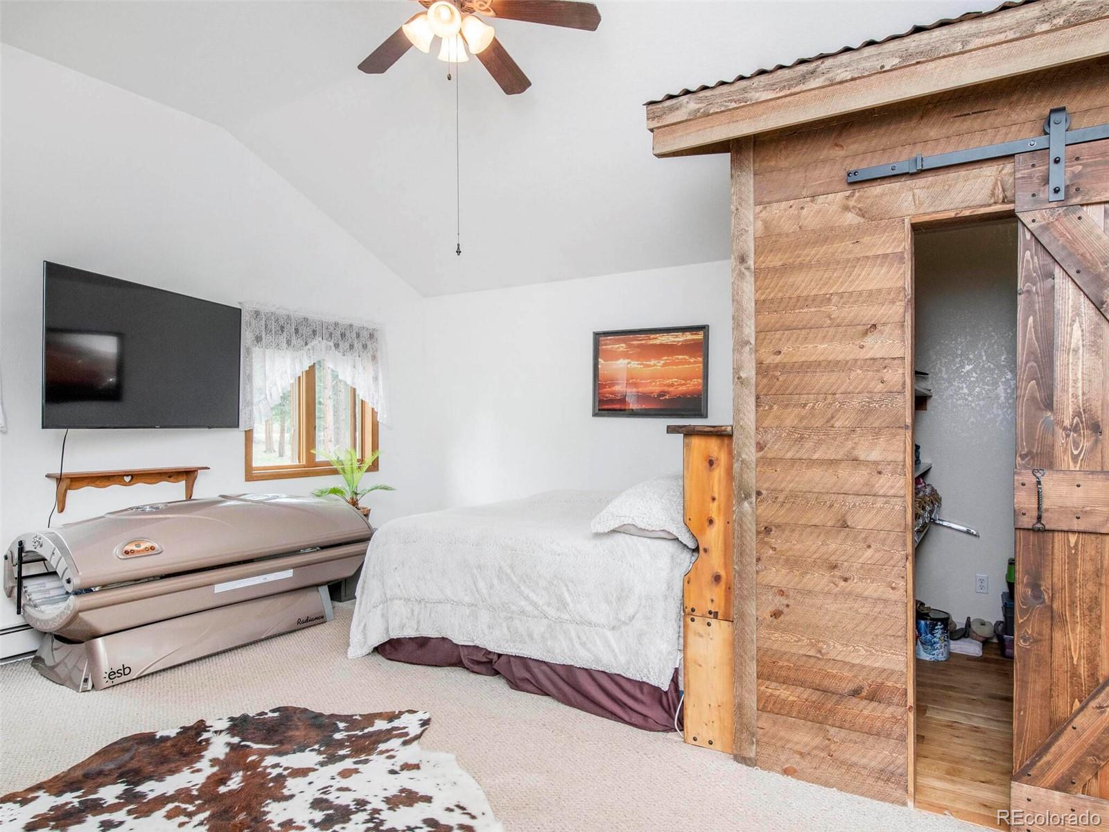 503 Conestoga Road Bailey, CO 80421 - Photo 20 of 40 a bedroom with a bed and a flat screen tv