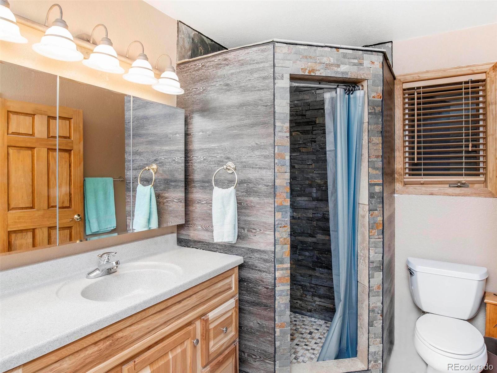 503 Conestoga Road Bailey, CO 80421 - Photo 28 of 40 a bathroom with a granite countertop sink toilet and shower