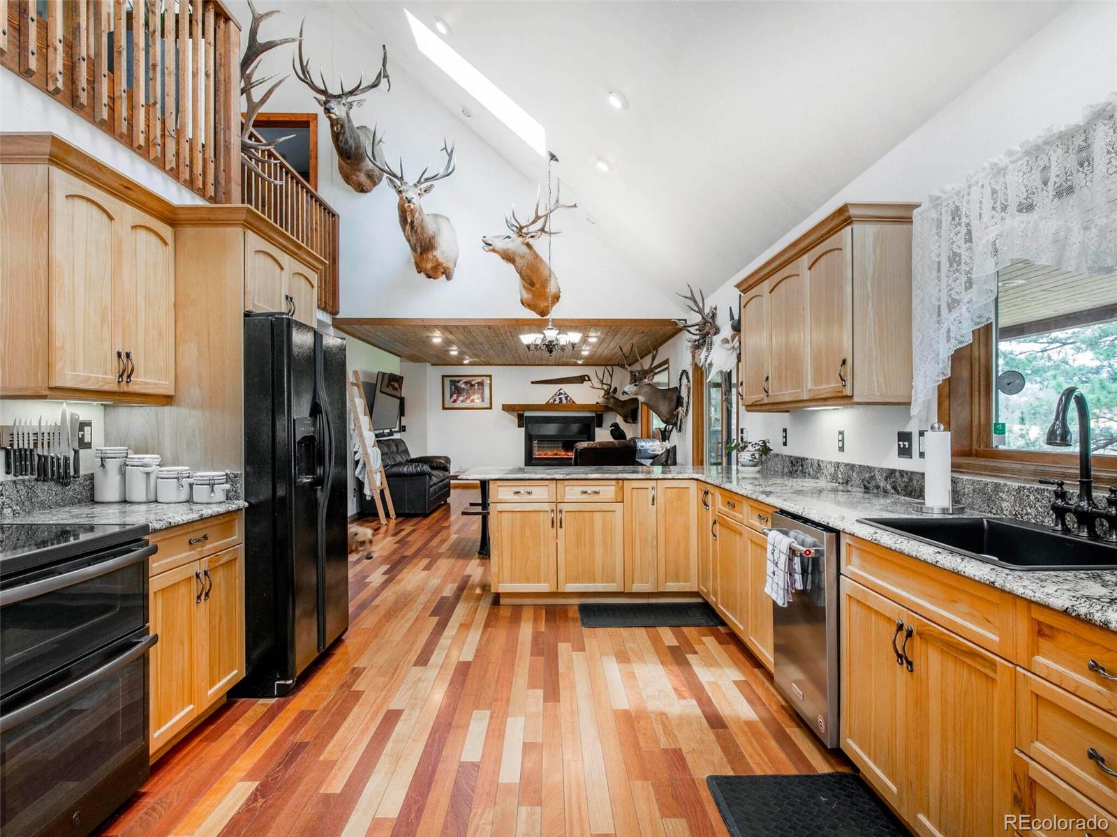 503 Conestoga Road Bailey, CO 80421 - Photo 5 of 40 a kitchen with stainless steel appliances granite countertop a sink and wooden cabinets