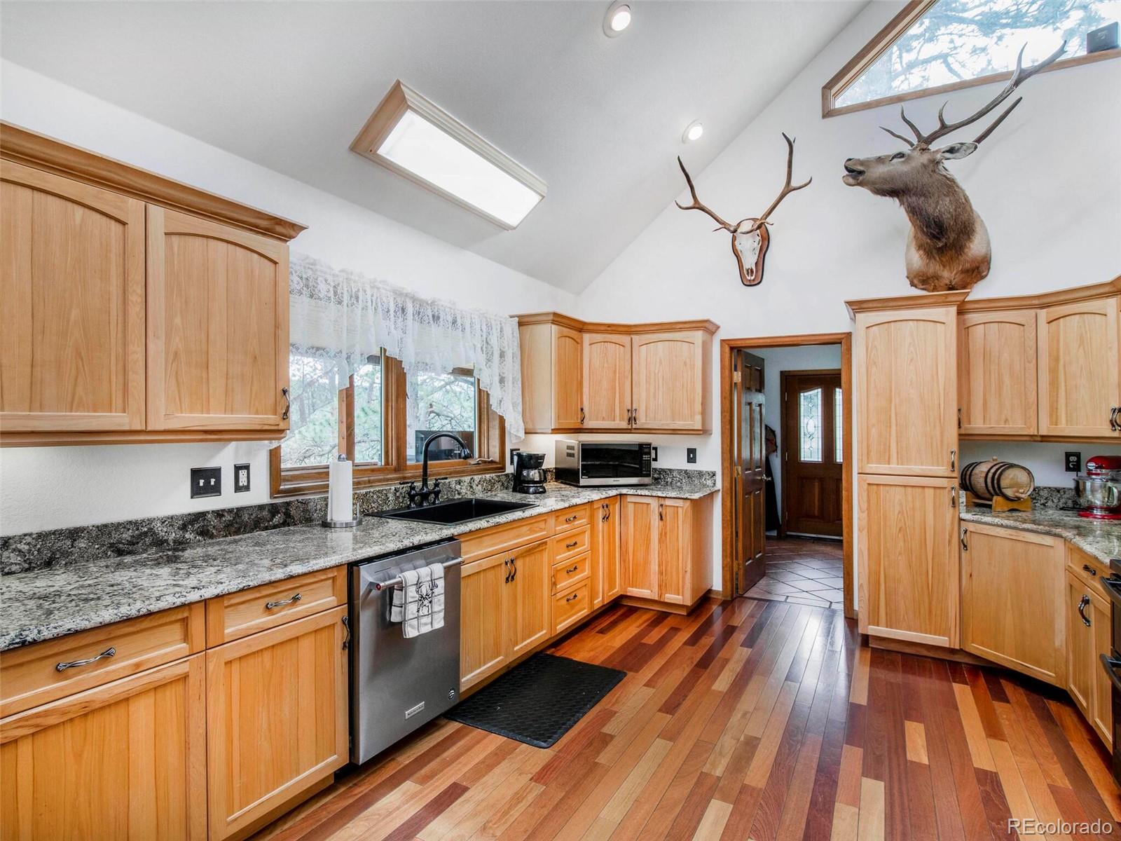 503 Conestoga Road Bailey, CO 80421 - Photo 9 of 40 a large kitchen with stainless steel appliances granite countertop a lot of counter space and wooden floors