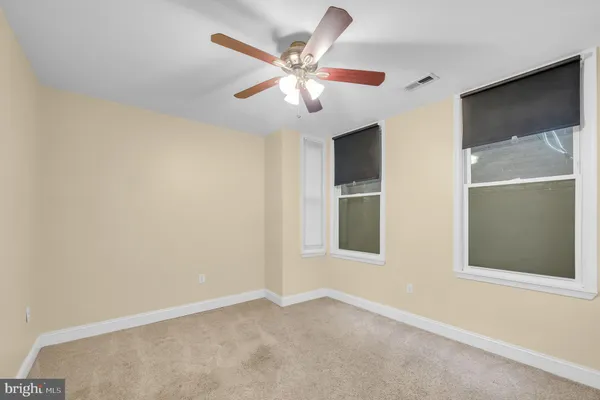 an empty room with closet and windows