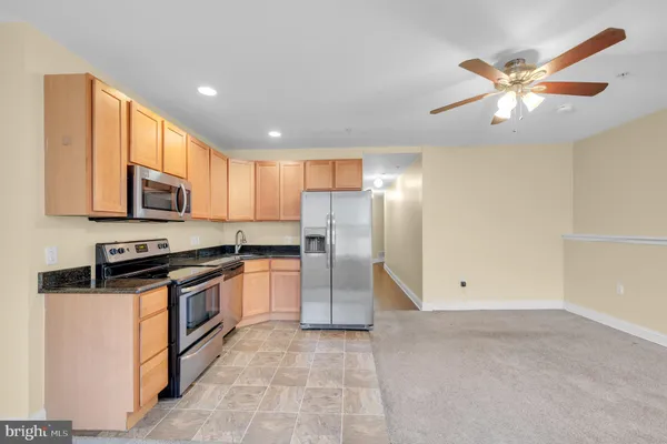 a kitchen with stainless steel appliances granite countertop a refrigerator a stove top oven a sink and dishwasher