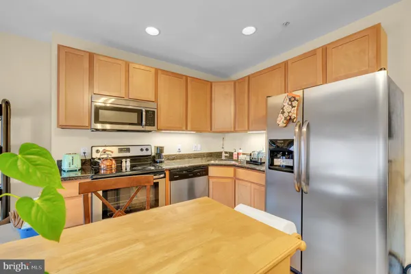 a kitchen with stainless steel appliances granite countertop a refrigerator a stove top oven a sink and dishwasher