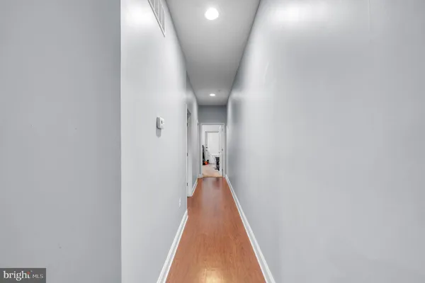 a view of a hallway with wooden floor