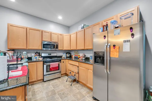 a kitchen with stainless steel appliances granite countertop a refrigerator sink stove and microwave