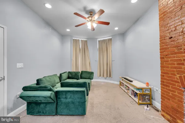 a living room with furniture and a ceiling fan