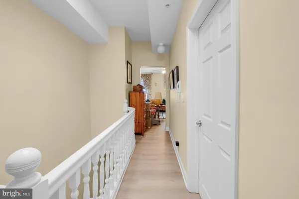 a view of a hallway with wooden floor and stairs