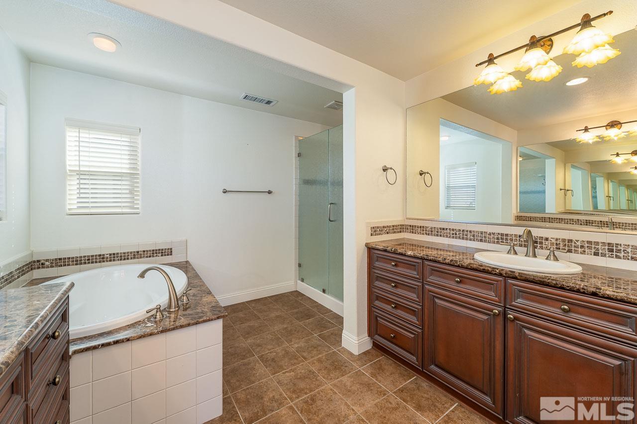 1935 Angel Ridge Drive Reno, NV 89521 - Photo 21 of 33 a bathroom with a granite countertop bathtub sink and mirror