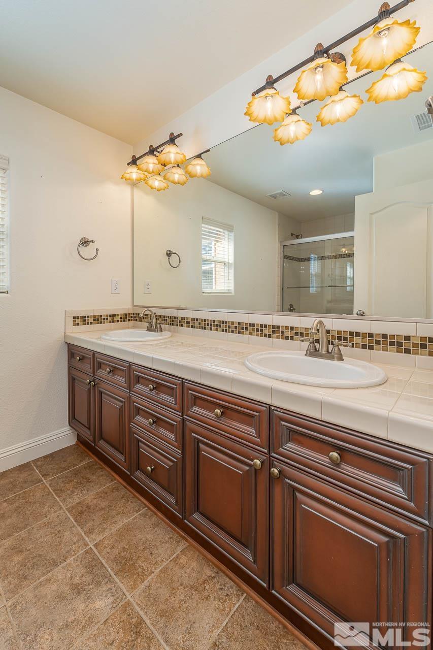 1935 Angel Ridge Drive Reno, NV 89521 - Photo 23 of 33 a spacious bathroom with a granite countertop sink and a mirror