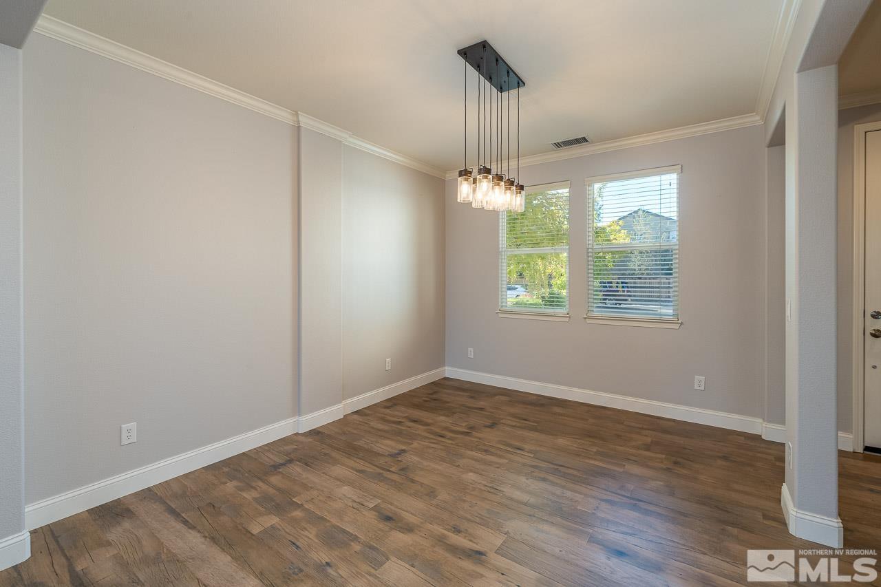 1935 Angel Ridge Drive Reno, NV 89521 - Photo 8 of 33 an empty room with wooden floor chandelier and windows