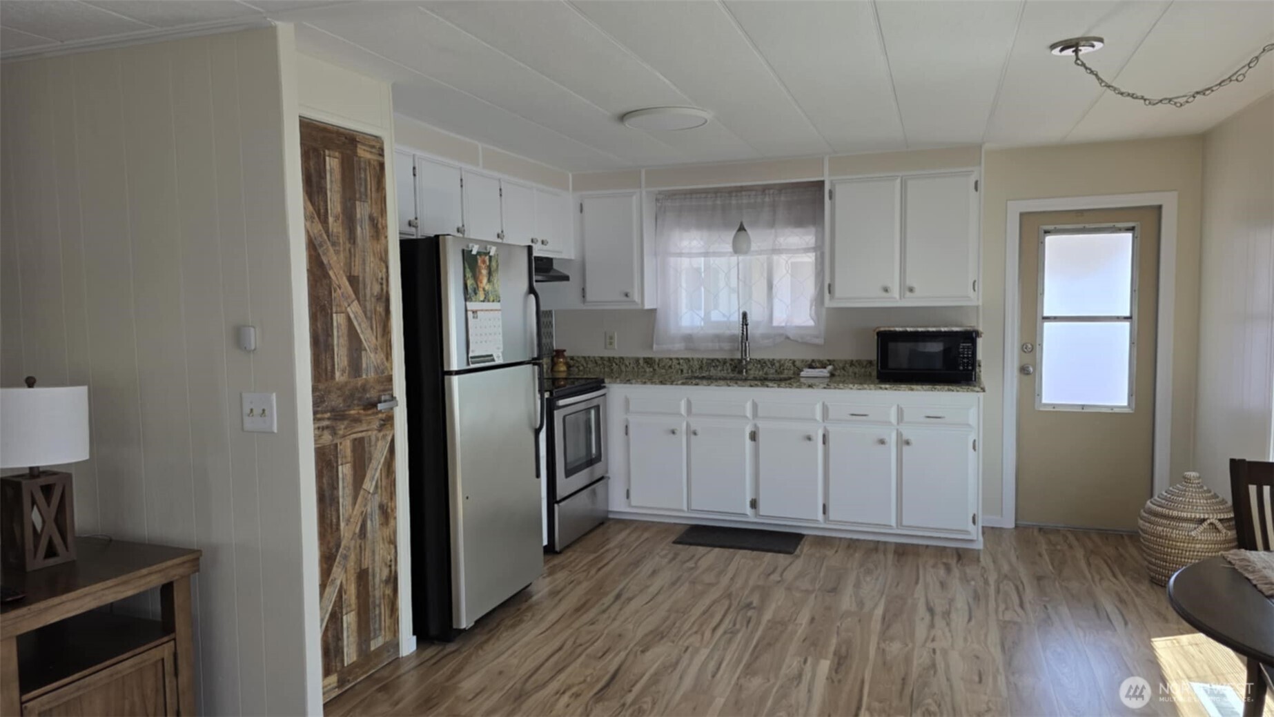 207 Ho Hum Lane Aberdeen, WA 98520 - Photo 10 of 22 a kitchen with a refrigerator wooden floor and a sink