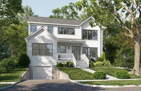 a front view of a house with a yard and trees