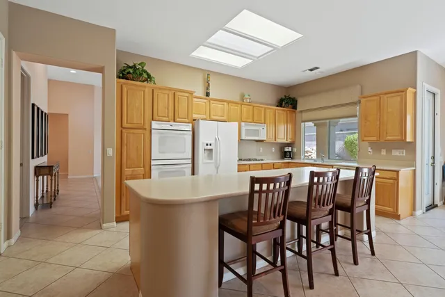 a kitchen with a table chairs refrigerator and cabinets