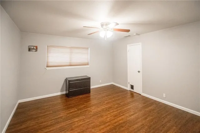 a view of a livingroom with wooden floor and a ceiling fan