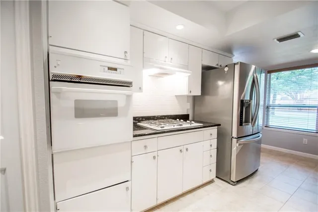 a kitchen with granite countertop a refrigerator stove and sink