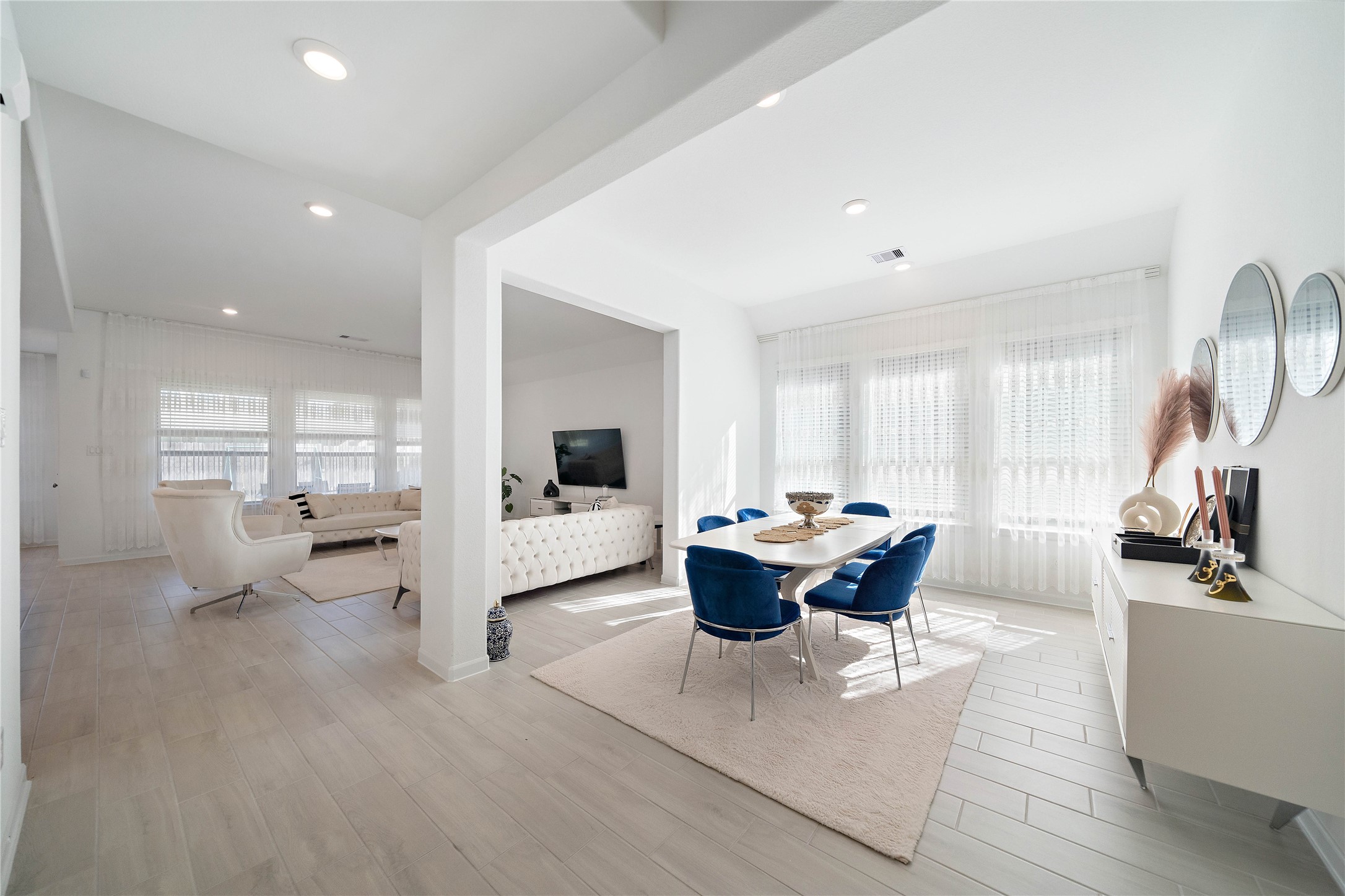 a living room with furniture a large window and a table