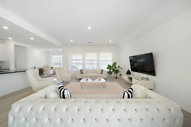 a living room with a couch a potted plant and a flat screen tv