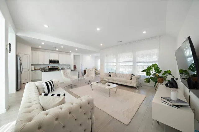 a living room with furniture kitchen and a chandelier