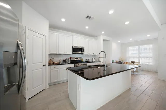 a kitchen with stainless steel appliances granite countertop a sink and refrigerator