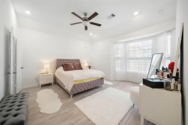 a bedroom with a bed and a large window